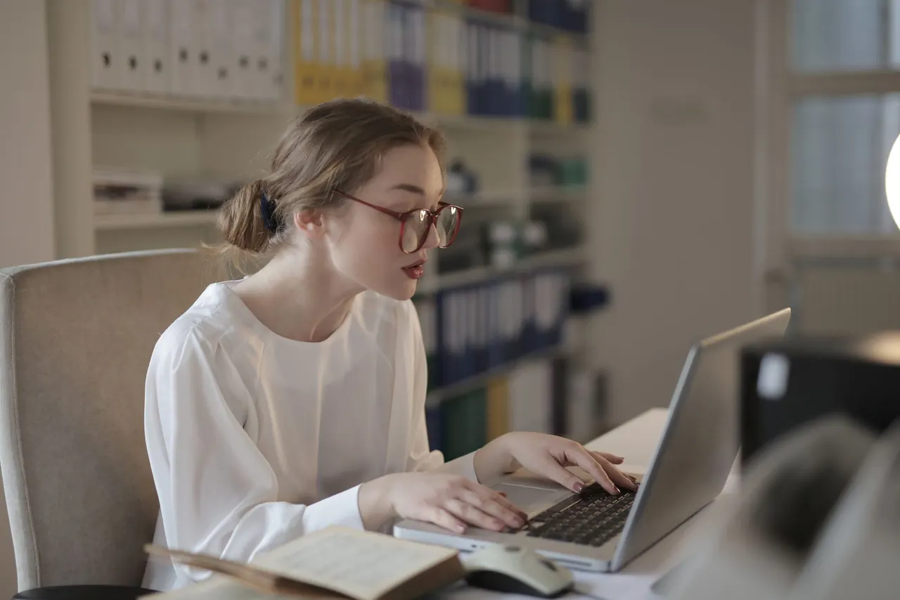 A professional working at a laptop in an office