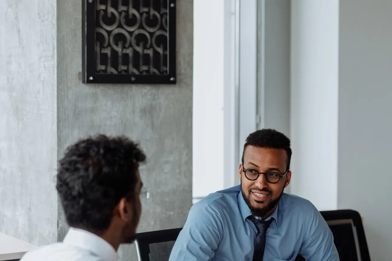 Two people talking across a table in an office